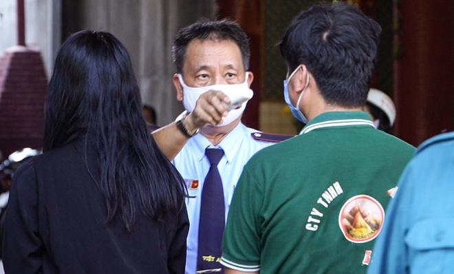 Bảo vệ đo thân nhiệt khách viếng tại lễ tang Mai Phương