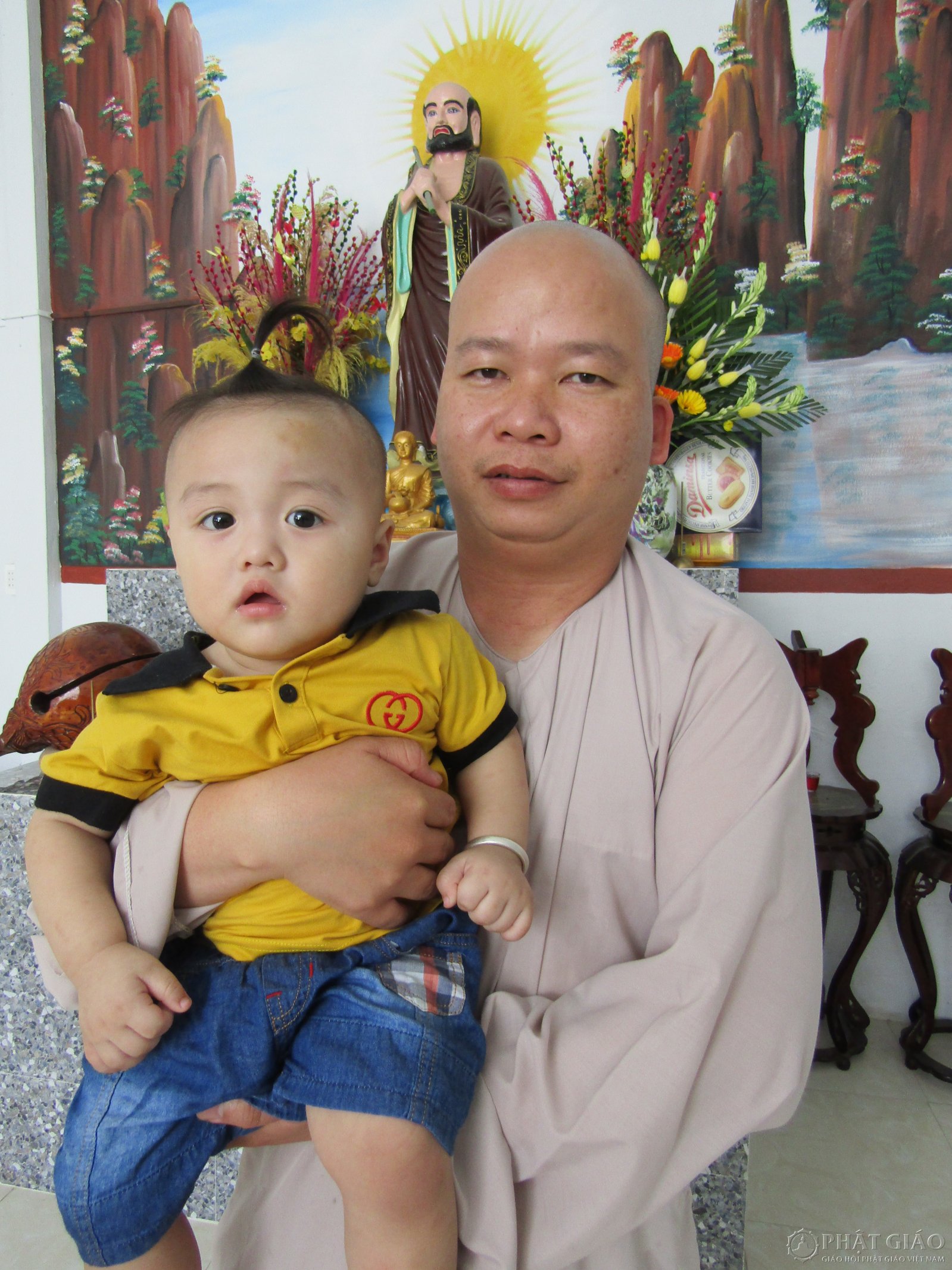 Đại đức Thích Tánh Bình cùng một em bé được chùa nhận nuôi